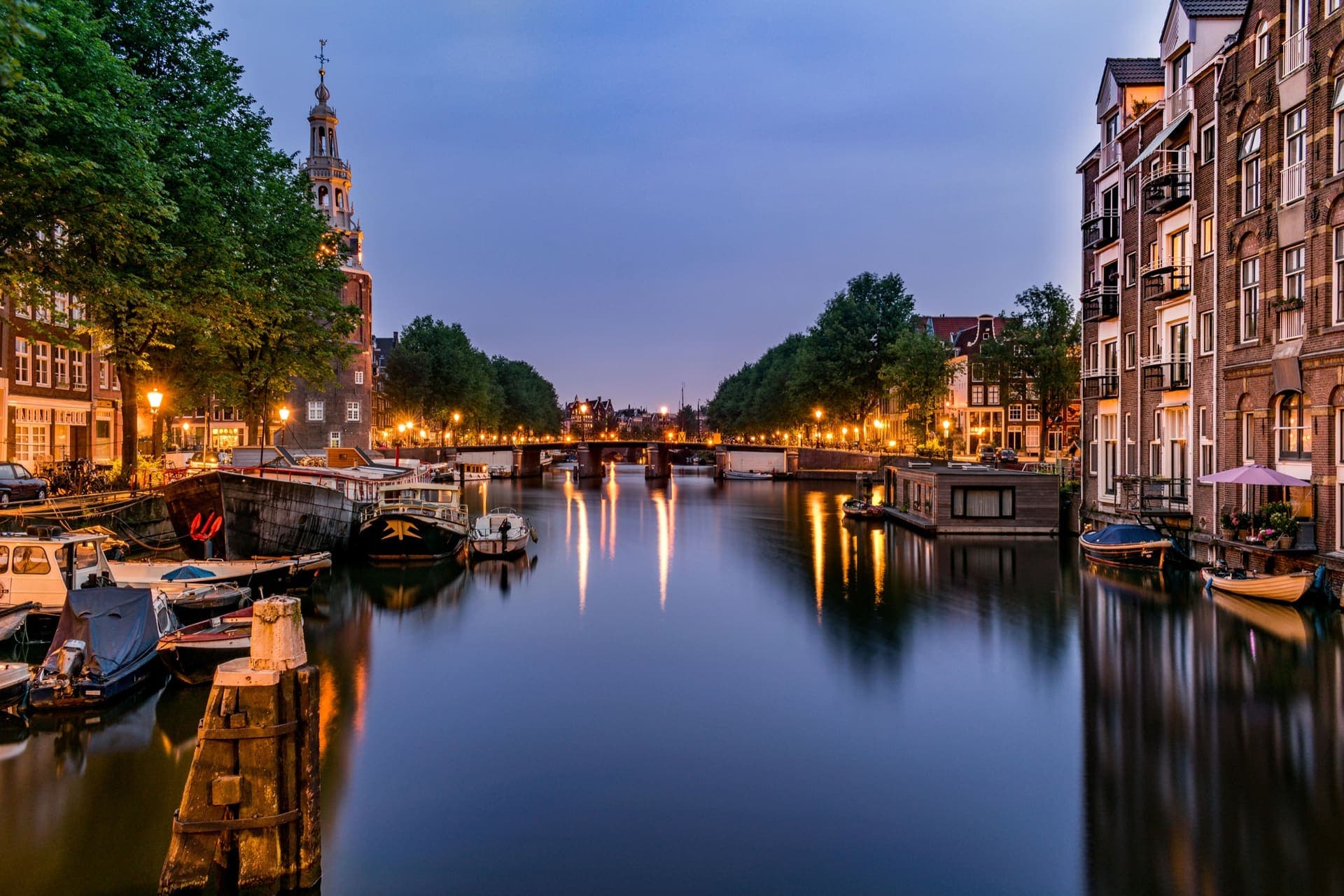 Amsterdamse gracht in het blauwe uur met verlichte panden