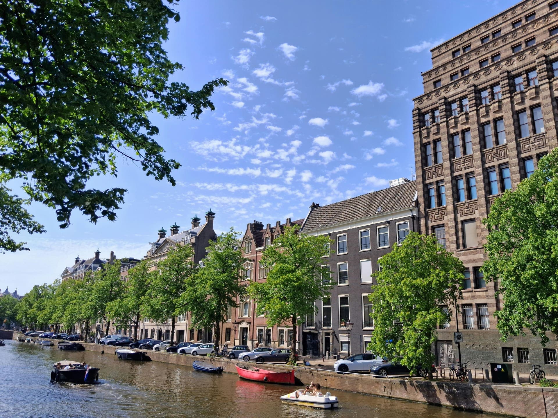 Amsterdamse grachtengordel met statige panden bij zomers daglicht